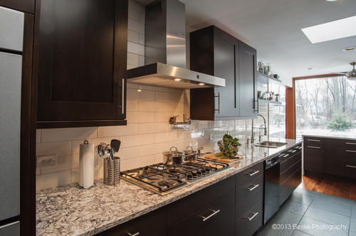Cambria Bellingham Countertop with Subway Style Glossy White Ceramic Backsplash, Truffle Stained Dark Kitchen Cabinets and Stainless Steel Hood